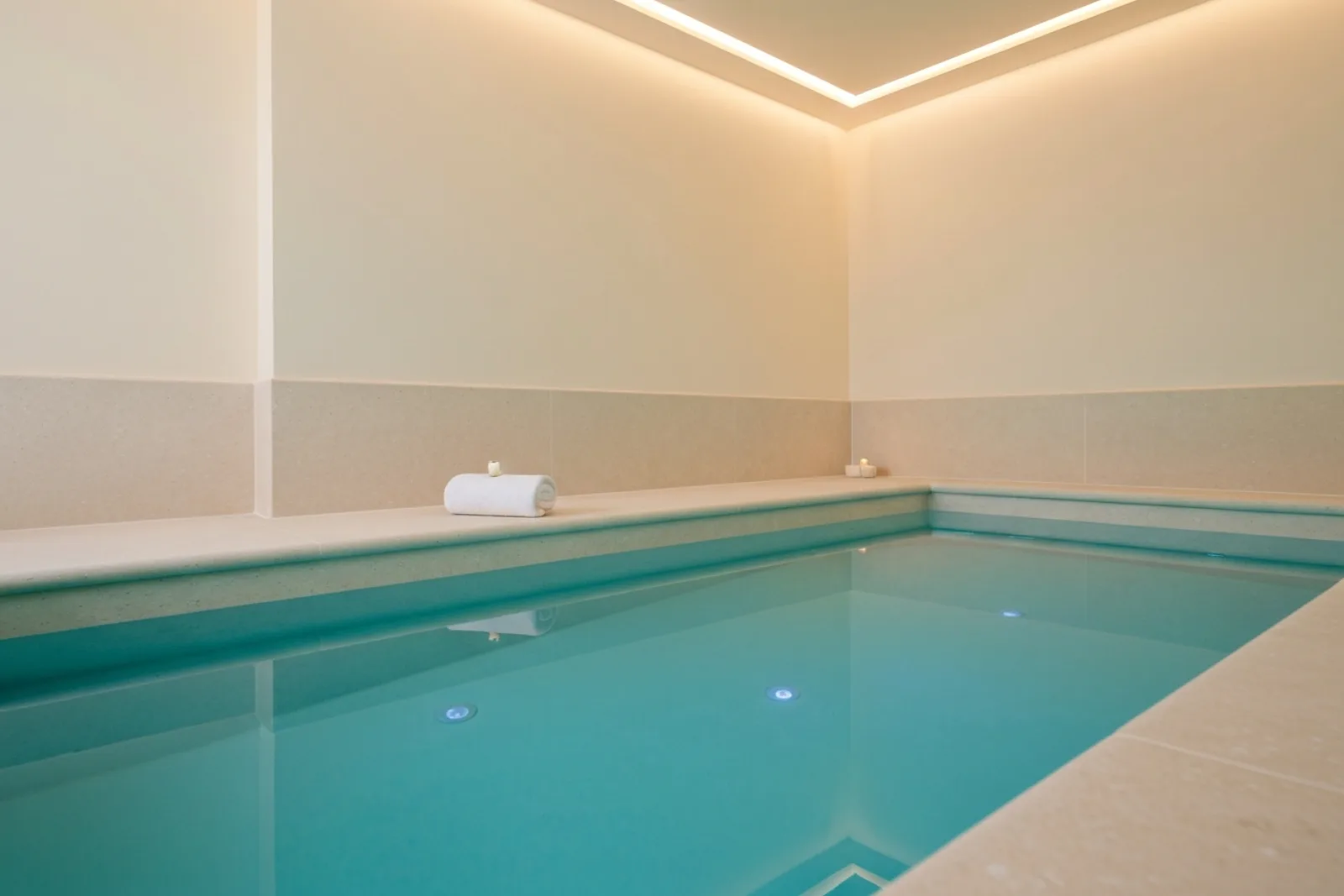 Minimalist indoor float therapy pool with glowing turquoise water at Sanya Eco Spa in Naxxar, Malta.